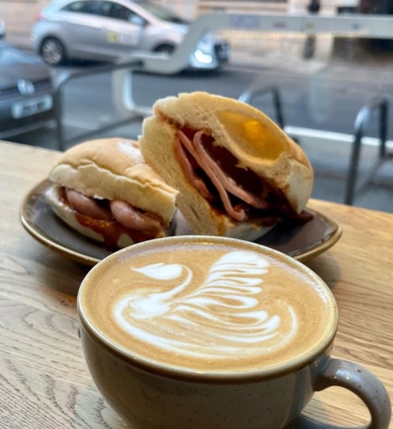 Bacon and sausage rolls with a latte