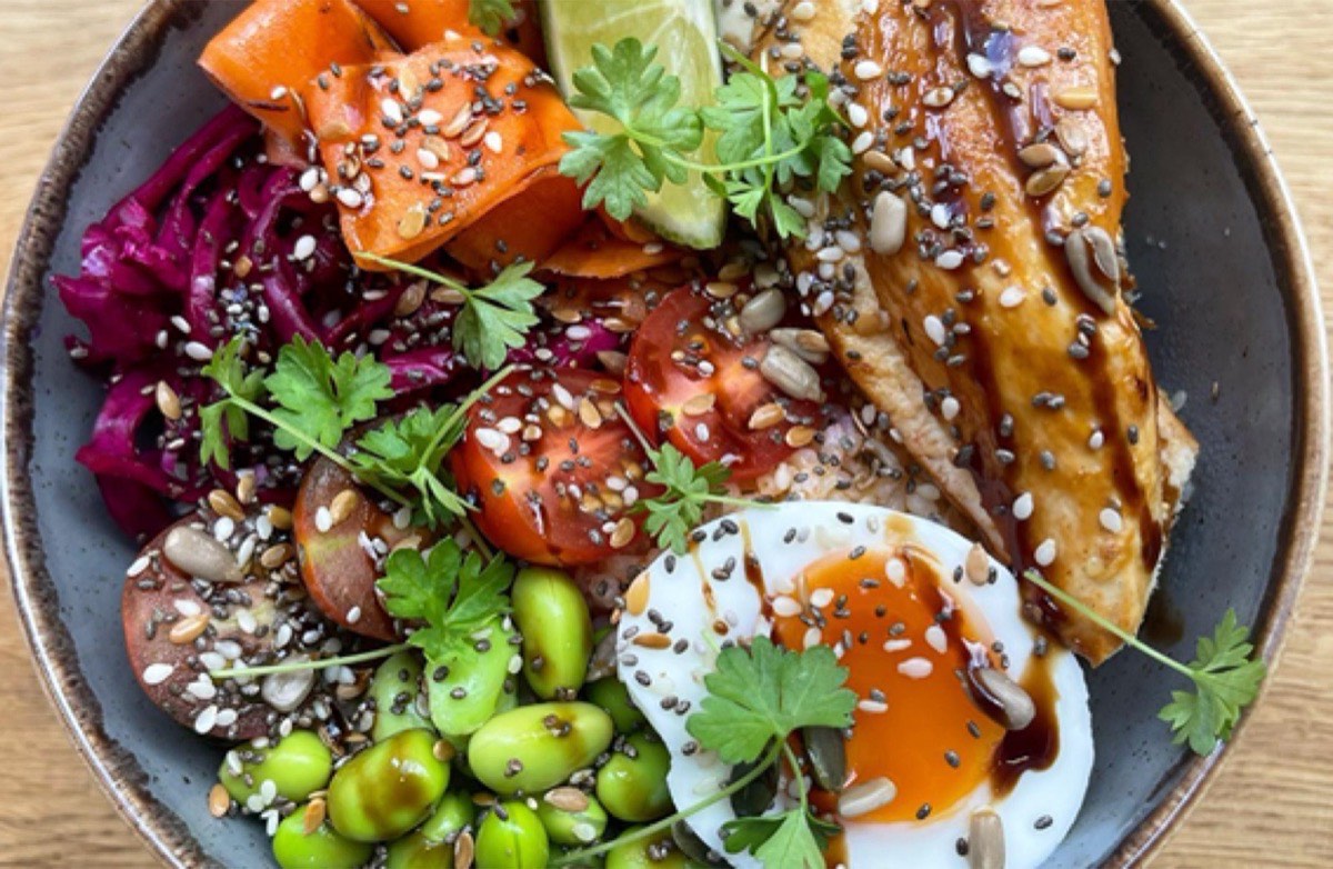 Colourful lunch bowl with soft egg, edamame and salmon