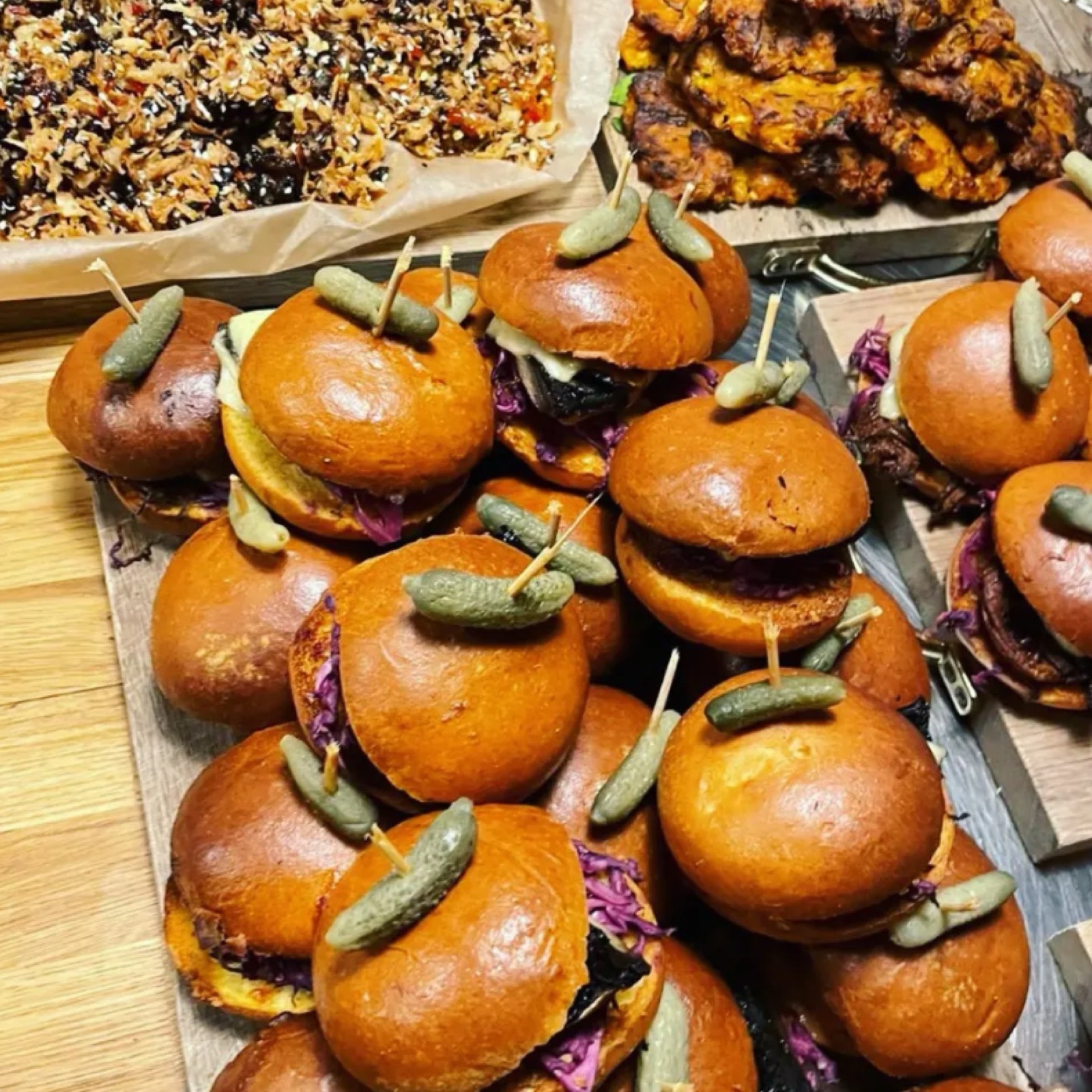Trays of burger sliders with gherkins and platters of food